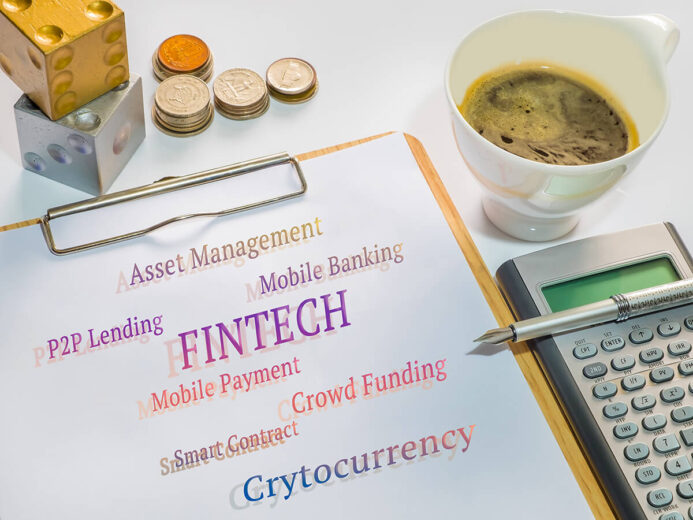 Fintech concept. Fintech application messages on sheet with clipboard, cup of coffee,, Calculator, pen, coins and dices.